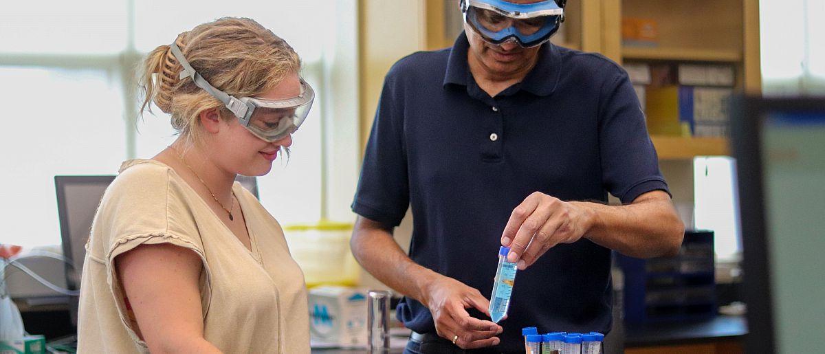 Image of Susquehanna professor and student in chemistry lab with beakers.